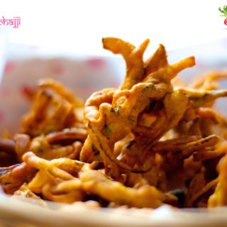 A close up of onion fritters in a basket lined with butter paper with hearts on it