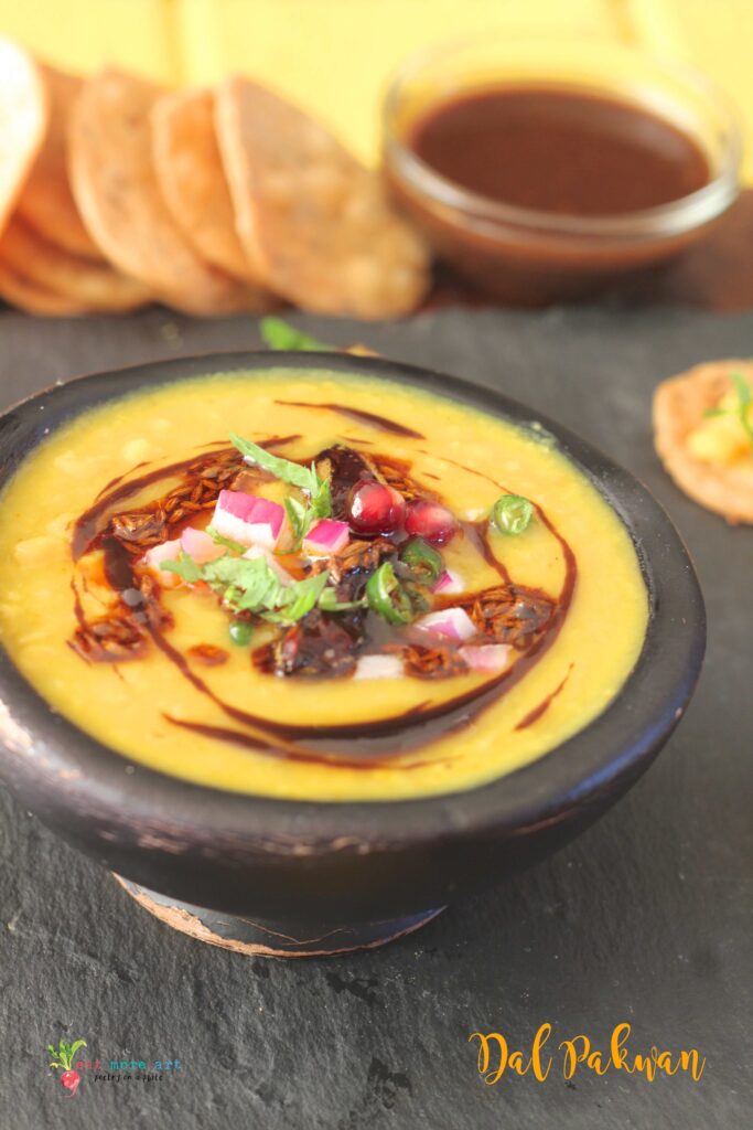 An overhead shot of Dal garnished with chutneys and condiments for Dal Pakwan