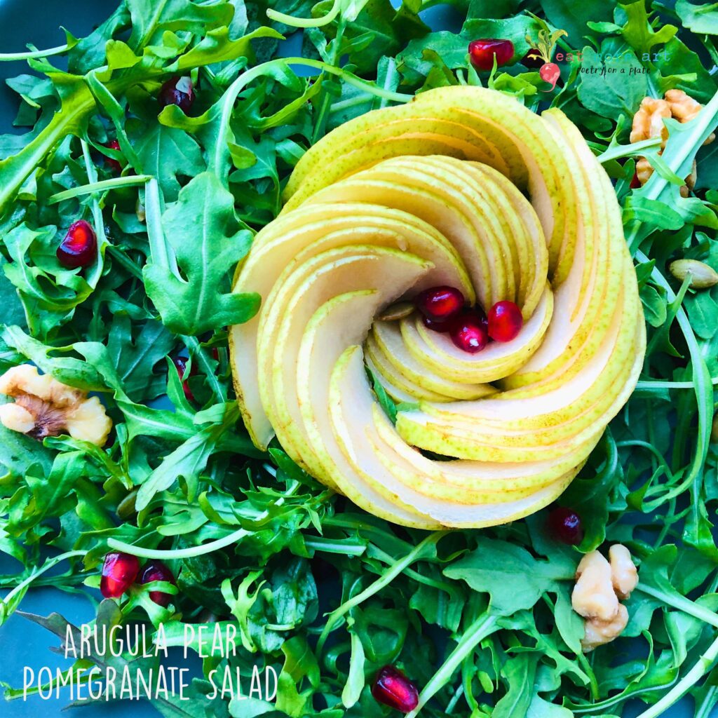 A closeup shot of arugula pear pomegranate salad 